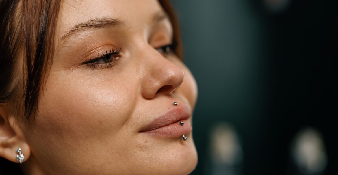 Satisfied beautiful girl after lip piercing beauty concept close-up face earring lip