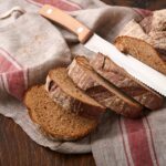 Fresh homemade rye bread. Traditional spelled sourdough bread cut into slices on a rustic wooden bac
