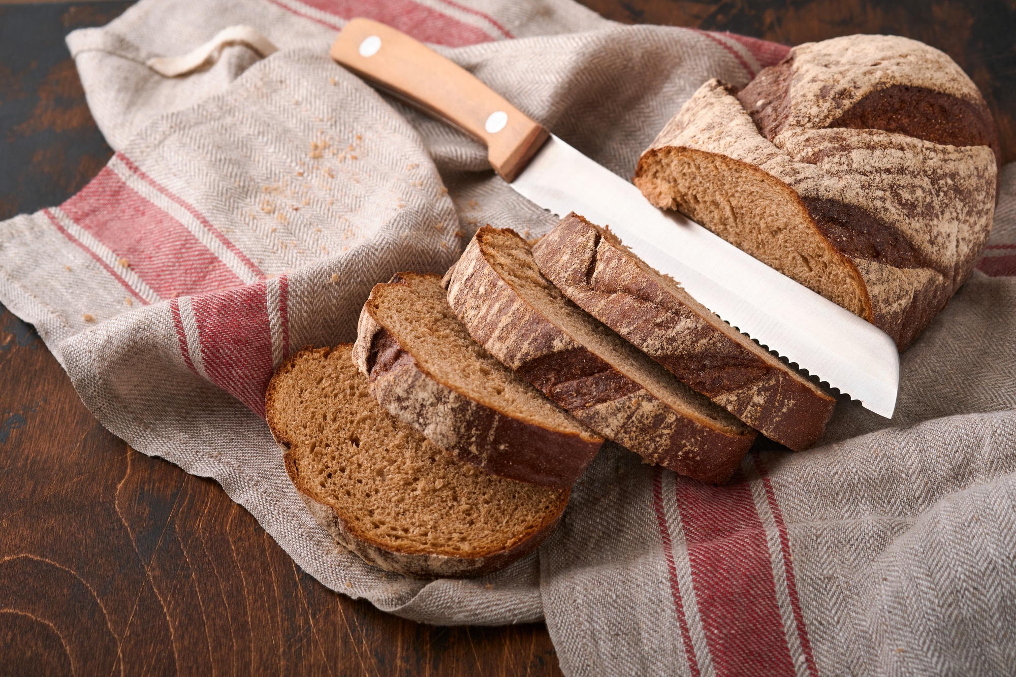 Fresh homemade rye bread. Traditional spelled sourdough bread cut into slices on a rustic wooden bac